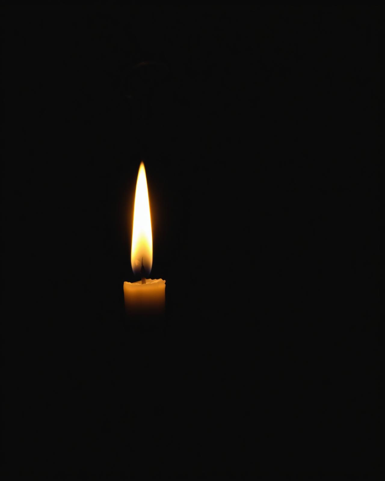 Vela branca acesa em ambiente escuro para ritual noturno de prosperidade